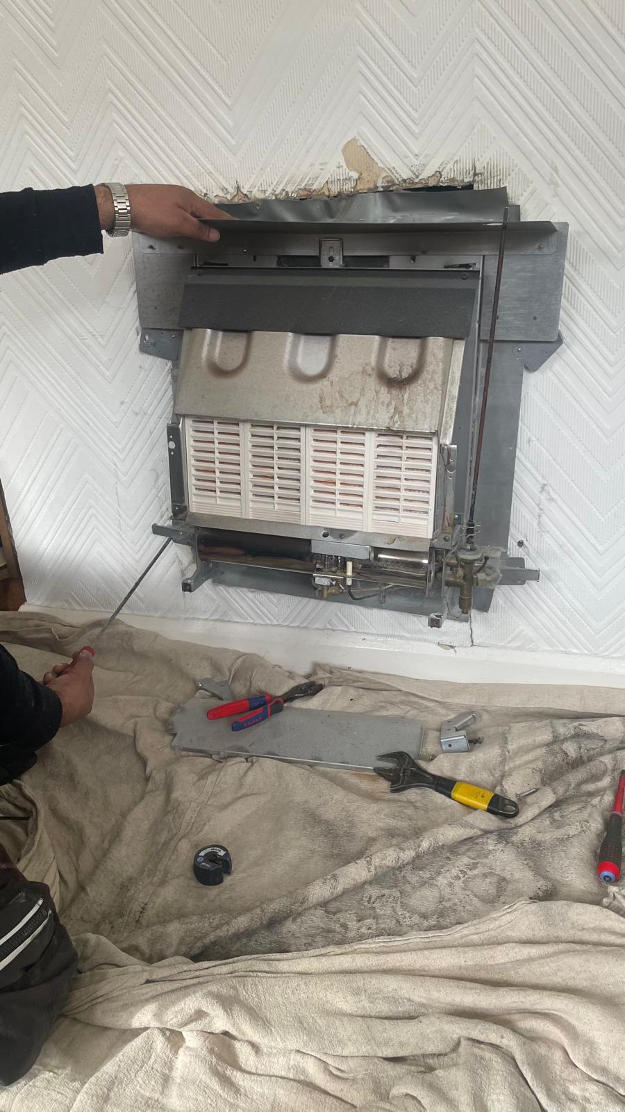 New gas fire being positioned into the fireplace opening in Wednesbury