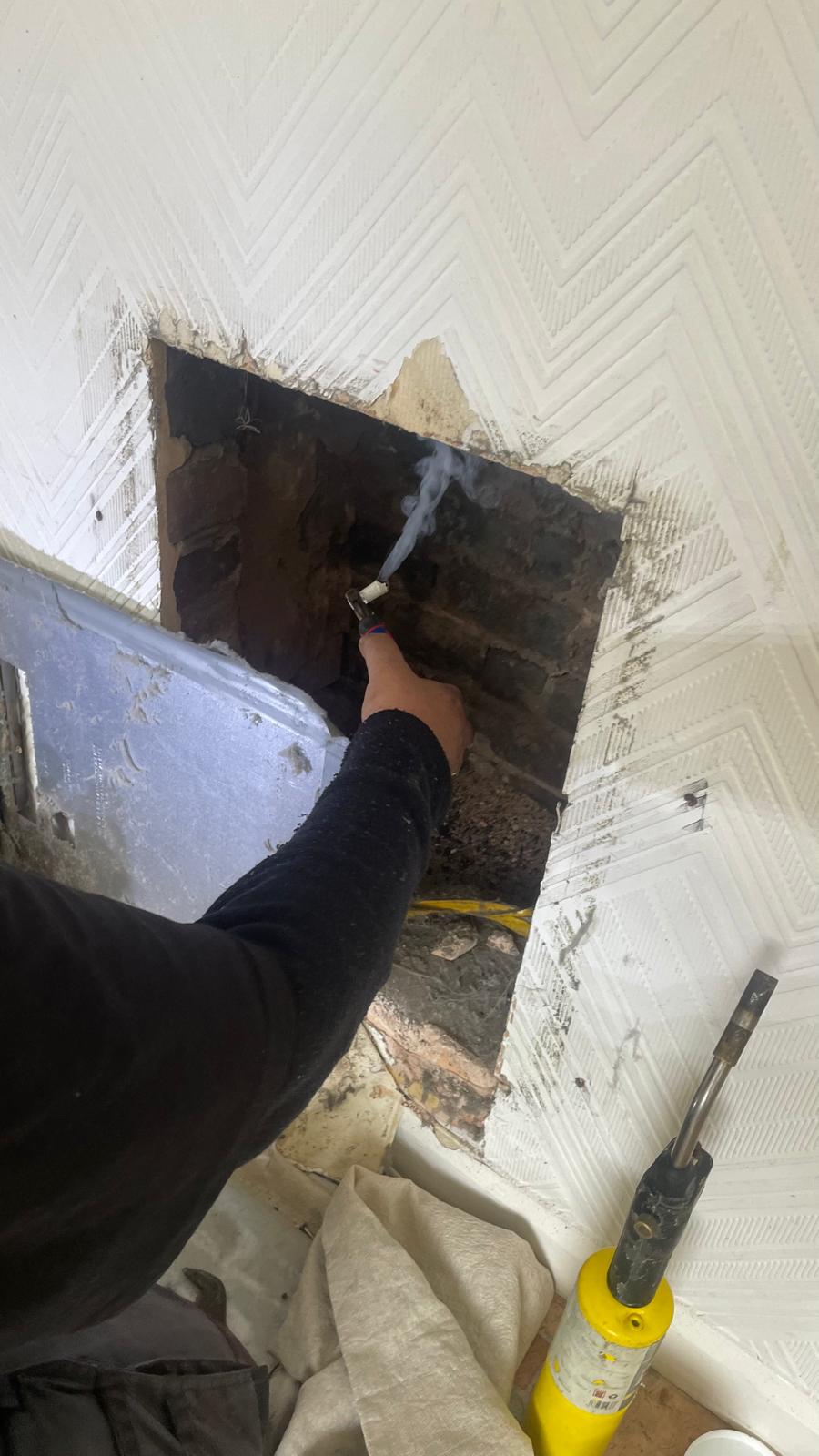 Chimney smoke test being carried out inside the fireplace opening