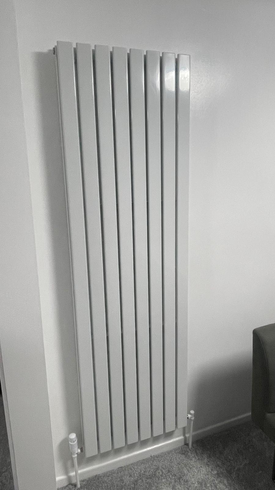 White vertical designer radiator close-up showing clean pipe connections in Walsall
