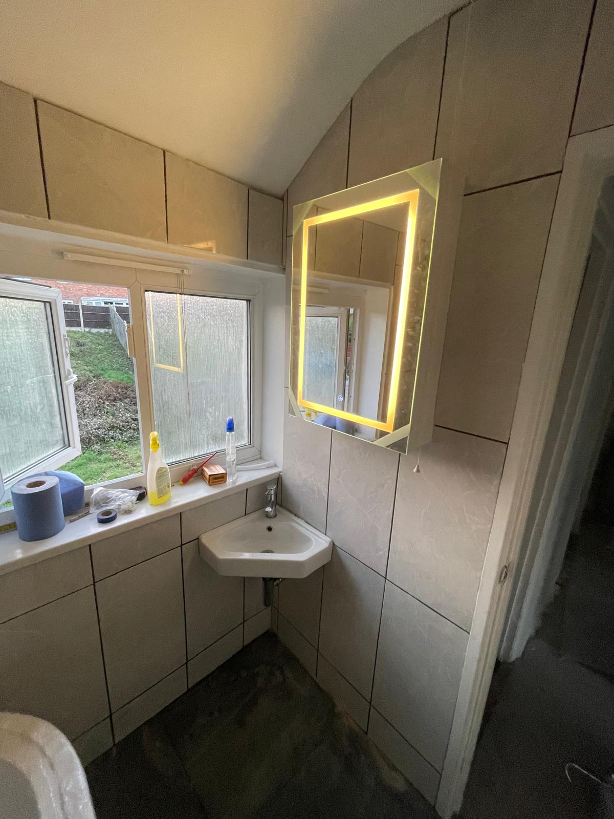 Corner basin with light-up mirror and tiled walls in Wednesbury bathroom
