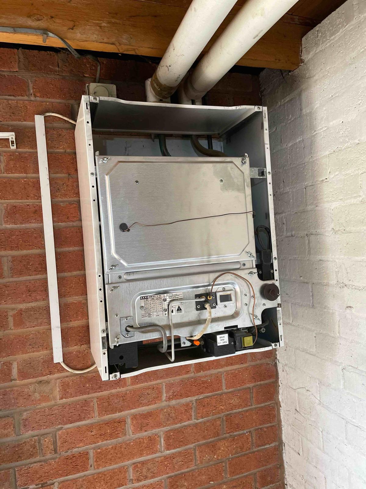 Old Baxi boiler with cover removed showing worn internals before replacement in Walsall