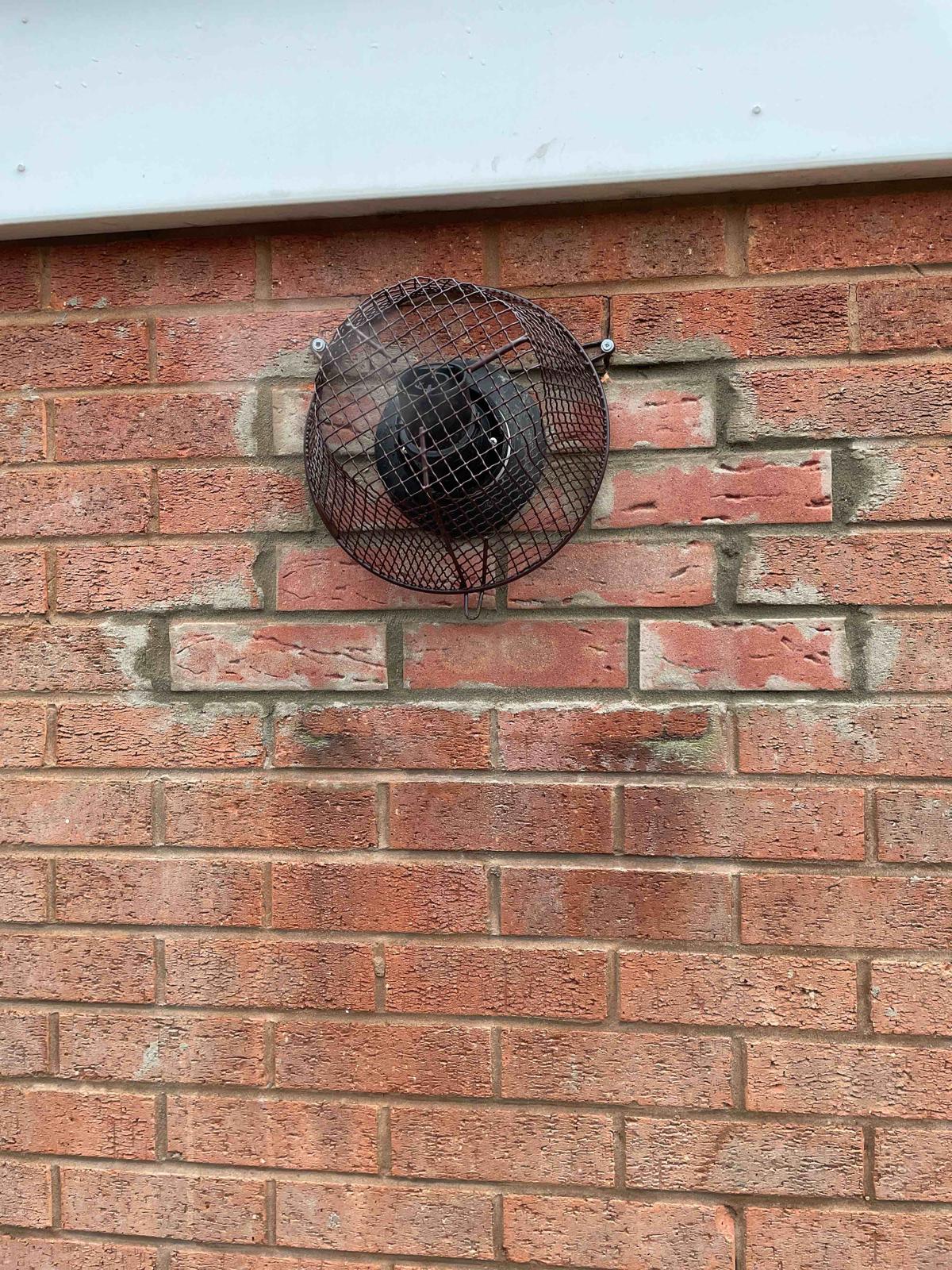 Close-up of new boiler flue terminal with guard fitted into new brickwork in Walsall