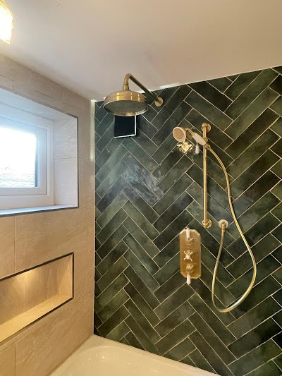 Built-in shelving niches above corner bath with warm lighting