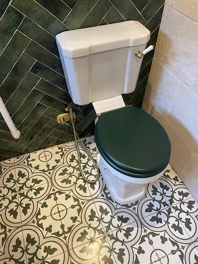 Recessed shelving and corner bath with gold taps