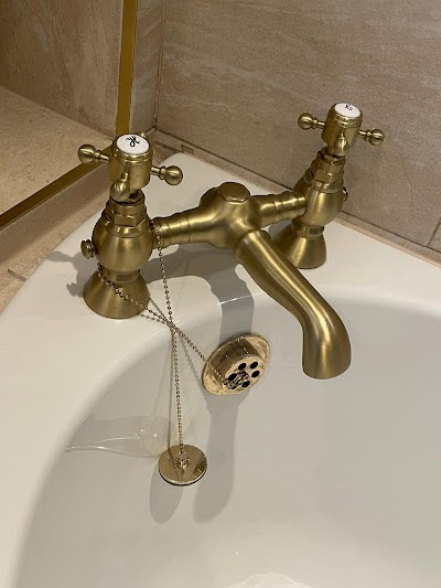 Victorian-style toilet with gold fittings and patterned floor tiles