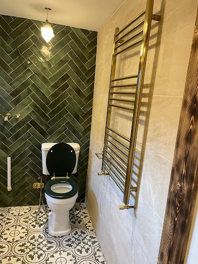 Gold towel radiator mounted on tiled wall